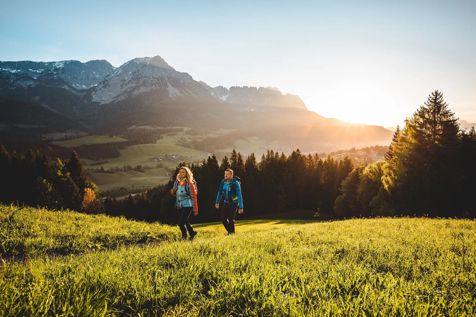 Wanderer bei Sonnenaufgang mit Blick auf den Wilden Kaiser