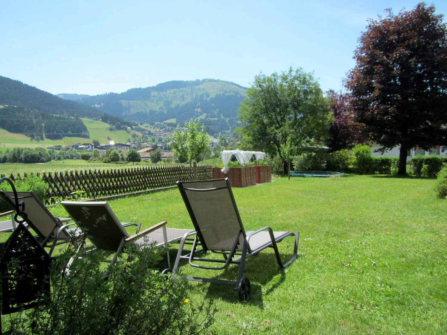 Gartenseite des Hauses mit Blumenschmuck und Willkommensschild